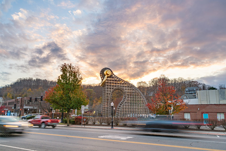 A large outdoor sculpture with cars passing by in the foreground