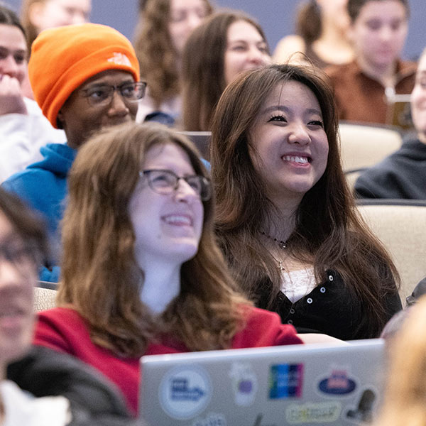 Two students sit outside at a table studying.