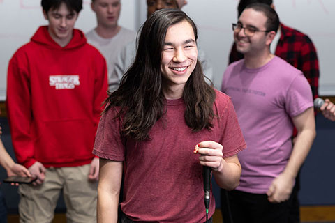 Devyn O. smiling and holding a microphone