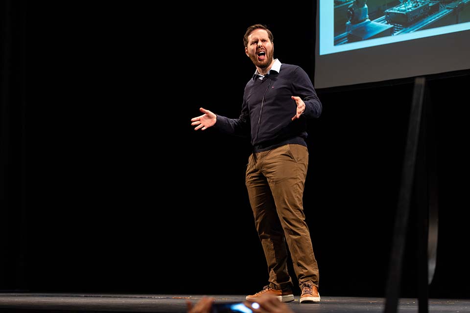 Josh Perlmutter presents his three minute thesis on stage.
