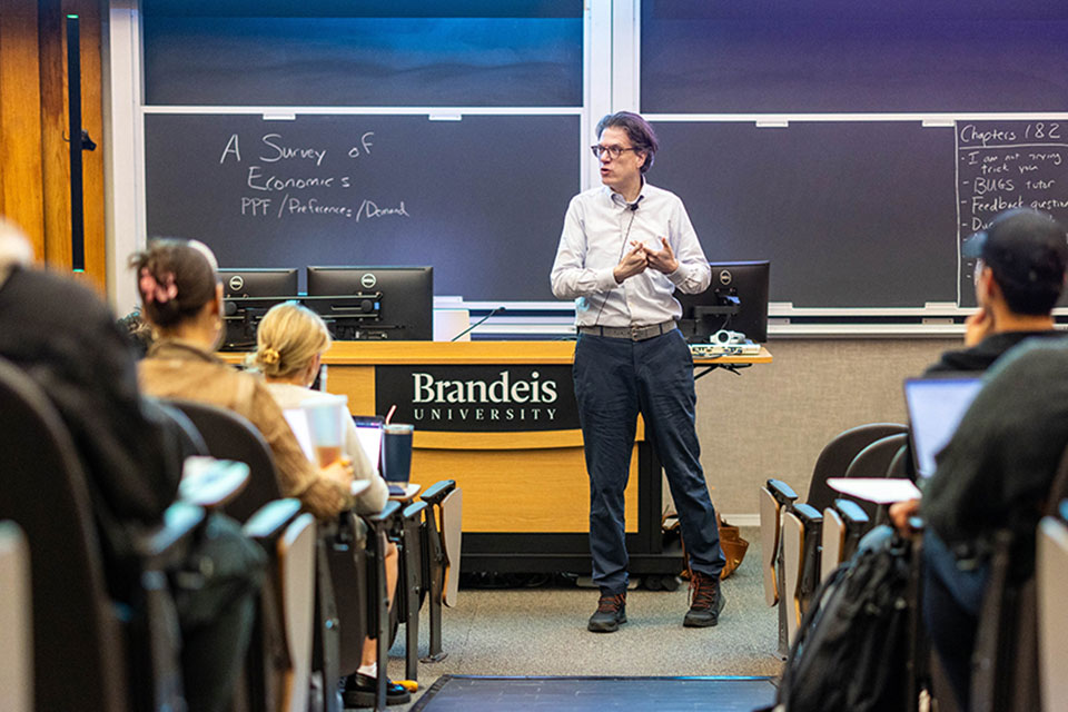 A professor gives a lecture to a room full of students.