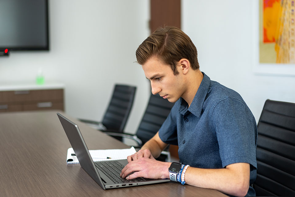 Matthew Pfeffer working on a laptop at his law firm internship.