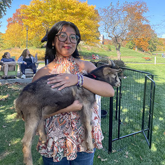 Photo of Ria holding a baby goat from Brandeis's "The Vote Goat" event