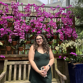 Sam standing in front of a tree with pink leaves