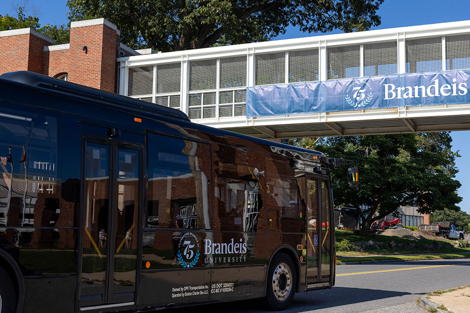 The Brandeis bus passes below a bridge on campus.