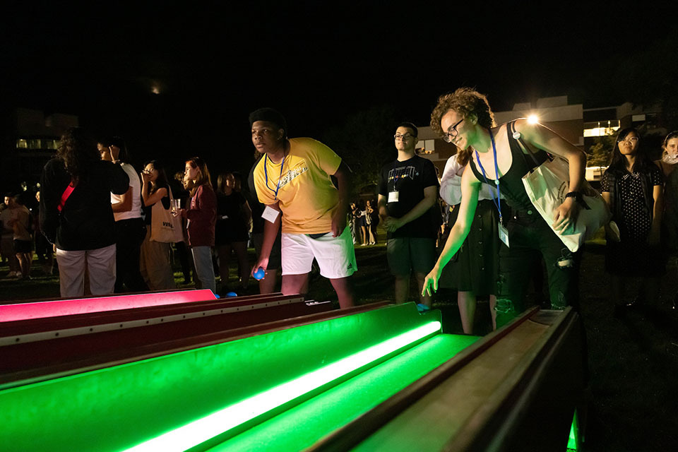 Two new students playing skeeball at the Orientation carnival event.